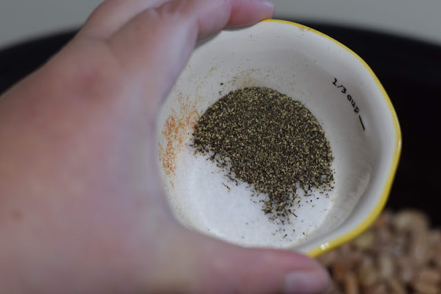 Salt and pepper being added to the crockpot. 