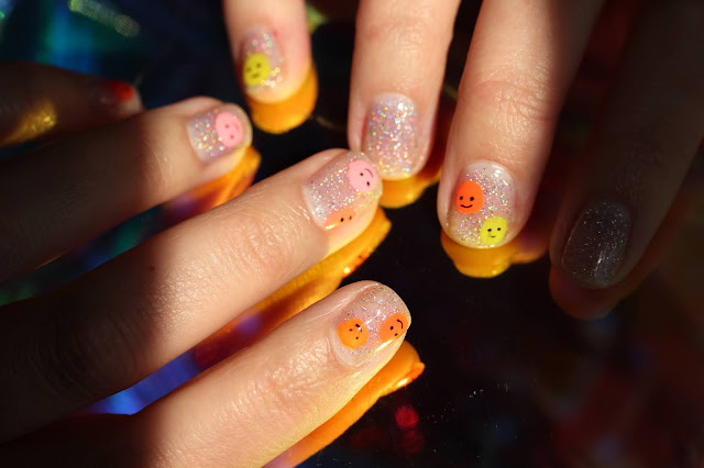 Easy smiley face nail art featuring a sparkly background