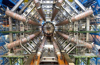  Onde está o bóson Higgs?[Imagem: CERN] Higgs, qual Higgs?  Você certamente se lembra da "descoberta" do bóson de Higgs, anunciada em 2012 - François Englert e Peter Higgs receberam o Nobel de Física um ano depois por terem previsto sua existência.  Mas você talvez também se lembre de como o anúncio foi feito - um anúncio cheio de senões, onde se falava uma coisa ("Descobrimos o Bóson de Higgs"), mas se escrevia outra ("Descobrimos 'um' bóson de Higgs").  Vários anos depois, e muitos mais dados coletados, os físicos continuam sem saber exatamente o que encontraram.  "Até agora nós não temos certeza se [a partícula encontrada pelo LHC] é o Higgs do Modelo Padrão ou um impostor misturado com algum outro tipo de Higgs. Estamos desesperados para descobrir o que está além do Modelo Padrão. O Higgs é a nossa janela para ir além do Modelo Padrão," disse Usha Mallik, física da Universidade de Iowa, nos EUA.  "Aparente descoberta"  Para tentar tirar as dúvidas e assumir de vez o Bóson de Higgs, ou abrir essa janela para um novo mundo da física, Mallik está à frente de um esforço para que o LHC procure por uma outra partícula, a única que pode tirar de vez a dúvida sobre o que foi observado em 2012.  Acontece que o Bóson de Higgs autêntico, ao decair - e ele decai muito rapidamente - deve produzir um par de quarks específicos (tipo bottom) em 60% das vezes.  Só que tem um problema: desde a "aparente descoberta" do Higgs, como Mallik a chama, o LHC não conseguiu detectar os tais quarks nenhuma vez.  Certamente a tarefa não é fácil: o bóson observado é gerado uma vez a cada 10 trilhões de colisões do LHC, e ele decai quase instantaneamente em outras partículas, o que torna a detecção e a definição dos elementos constituintes desse decaimento um desafio e tanto. Este é um dos motivos pelos quais os físicos estão construindo um novo LHC, mais potente.   "Até agora nós não temos certeza se [a partícula encontrada pelo LHC] é o Higgs do Modelo Padrão ou um impostor misturado com algum outro tipo de Higgs," afirma Usha Mallik. [Imagem: Tim Schoon] Subdetector  Para ajudar, Mallik e sua equipe estão trabalhando agora em um subdetector, um sensor que será anexado a um dos grandes detectores do LHC, o Atlas, e que foi projetado para detectar justamente o par de quarks bottom que o Bóson de Higgs deveria gerar.  A esperança é observar os tais quarks na confusão de partículas pós-colisão que surge do decaimento do Higgs ou de outras novas partículas pesadas semelhantes a ele.  "É basicamente identificar, pegar aquela agulha no palheiro sem se deixar enganar por outra coisa. Esse é o desafio," disse Mallik.  Agora é esperar pelos resultados para ver se a "aparente descoberta" do Higgs se transforma em uma descoberta autêntica.    FONTE: Tim Schoon