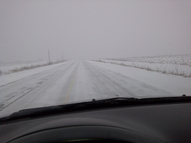 View out windshield of 100% snow covered road on rural highway