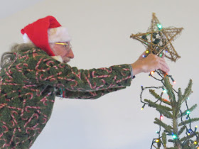 putting star on Christmas Tree