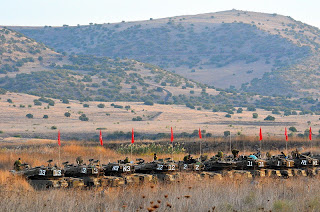 line of israeli tanks performing drill in golan heights israel