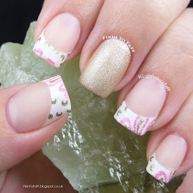 Matte French tip look in pink white and gold with gold glitter accent.