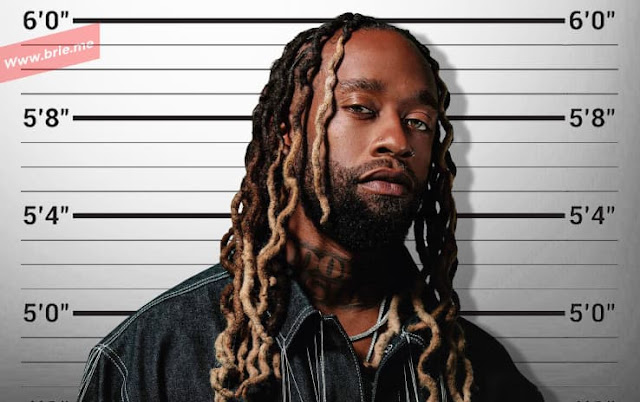 Ty Dolla Sign posing in front of a height chart
