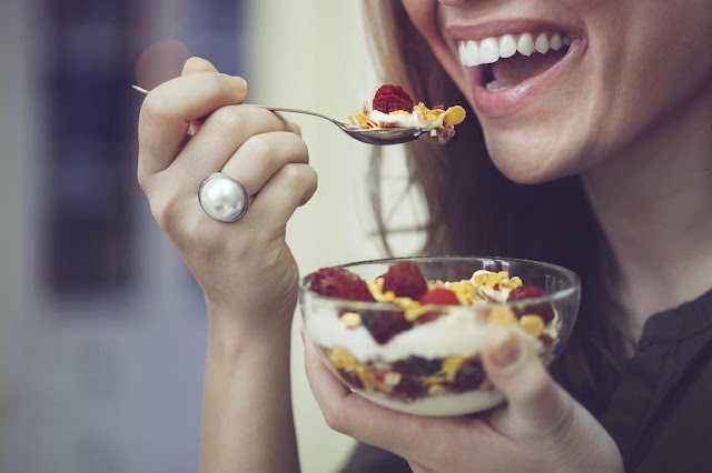 A woman enjoying a healthy meal, emphasizing the importance of making mindful food choices and portion control for effective and lasting fat loss