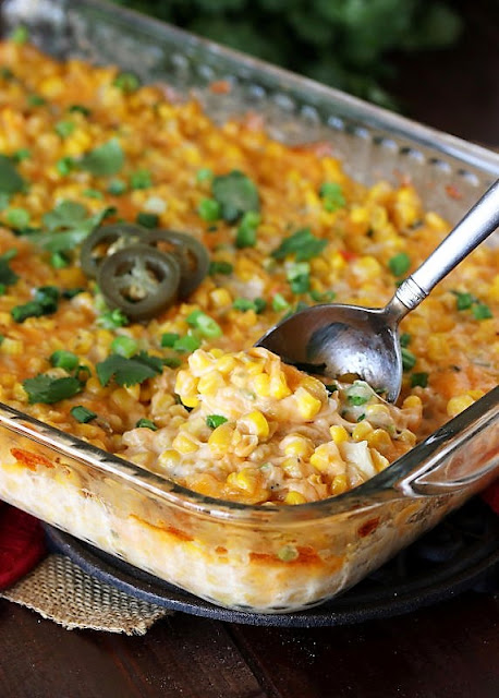 Cheesy Fiesta Corn Casserole in Baking Dish with Serving Spoon Image