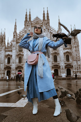 Mujer posando con un look en azules, grises y blancos