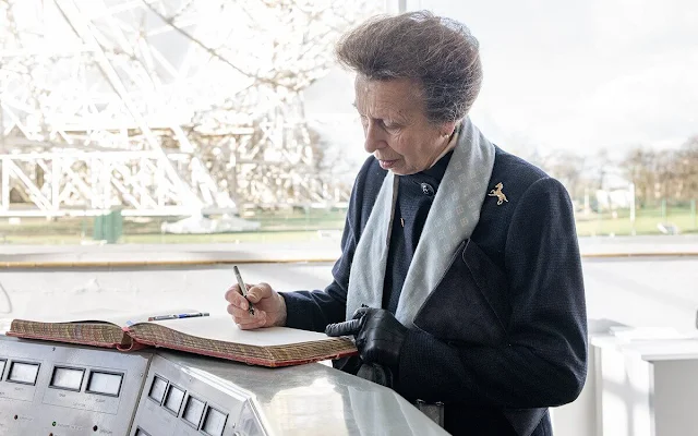 The Princess Royal wore a navy coat with a pale blue patterned scarf at Jodrell Bank Observatory