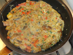 PORCIONES: 1 TORTILLA  INGREDIENTES 2 cucharadas de aceite de vegetal 3 papas pequeñas, lavadas y cortadas en cubos con la piel ½  taza de cebolla, cortada en cuadritos 2 dientes de ajos picados 1/3 taza de pimiento morrón rojo, cortado en cuadritos 1 taza de champiñones cortados en rodajitas 2 huevos batidos 1 cucharada de perejil picado ½ cucharadita de sal  PROCEDIMIENTO Calentar el aceite en una sartén, freír las papas y separar. Dejar un poquito del aceite en la sartén y sofreír la cebolla con el ajo y pimiento. Añadir los champiñones, perejil, ciboulette y cocinarlos livianamente. En un recipiente mezclar las papas, con el resto de los ingredientes. Calentar la sartén con un poquito de aceite y poner la mezcla revolviendo un poquito para que coagule los huevos. Dar vuelta la tortilla. Si no tiene experiencia, se pude ayudar con un plato dándola vuelta sobre este y después poner de vuelta en la sartén para que coagule ese lado. Servir inmediatamente.