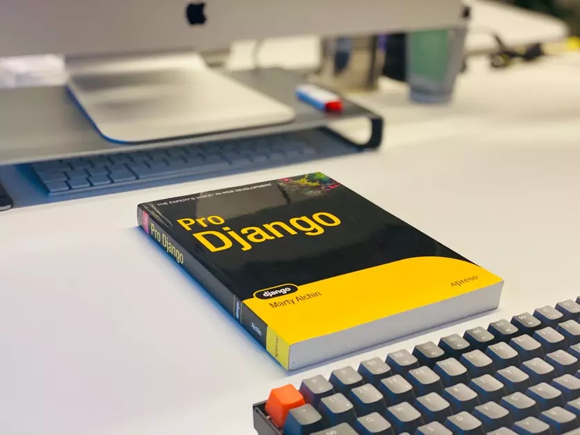 pro django book on a table with a keyboard