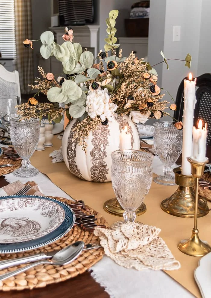 decoupage pumpkin centerpiece, blue and brown dishes, vintage doilies, candles