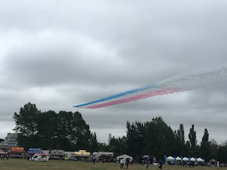 Red Arrows flying with red, white, and blue smoke behind them.