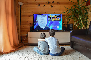 Deux enfants devant un écran de télévision