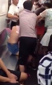 Woman (in orange skirt) nearly strips girl topless over train seat fight