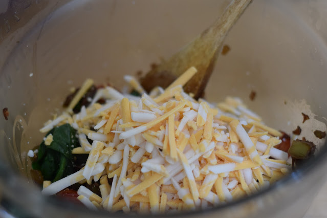 Vegan cheese being added to the mixing bowl.