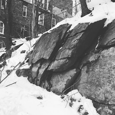 Snow builds up on a rocky outcropping near an apartment building in the Bronx borough of New York City.