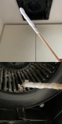 割りばしに綿を巻いたもので換気扇を掃除する写真