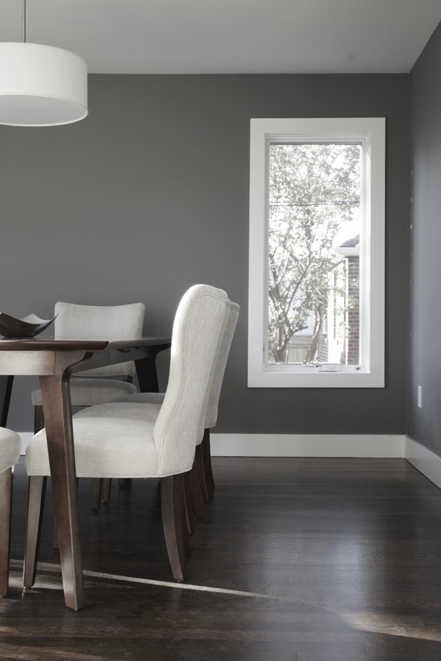 Picture of dining room with dark grey walls and dark wooden floor but light grey chairs