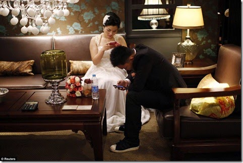 A couple waits to participate in a staged mass wedding, organised as part of a matchmaking event to inspire singles to get married, in a suburban area of Shanghai May 18