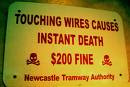 sign that reads touching wires causes instant death. two hundred fine