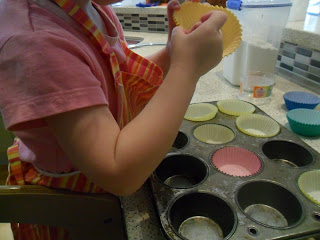 Lining a muffin tray with paper cases for the muffin recipe