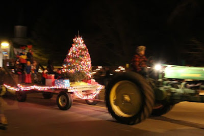 tractor pulling a Christmas tree on a hay wagon