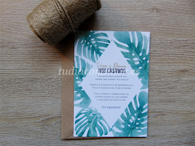 Invitación con texto en rombo y hojas pintadas en acuarela de estilo tropical