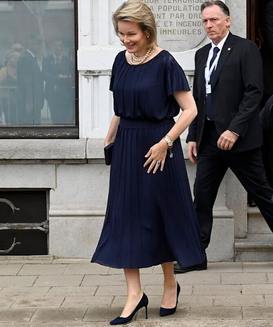 Queen Mathilde wore a navy blue pleated short-sleeve midi dress by Emporio Armani. Jimmy Choo navy pumps, Olga Berg ava clutch