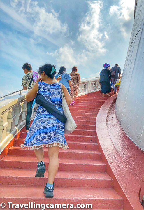 A climb to the top of the mount is a journey of more than 300 steps. Visitors are treated to several resting spots and viewpoints while climbing the many steps leading to the top of the mount. Like above photograph shows people climbing up and also looking around the temple & enjoying Bangkok landscapes. 