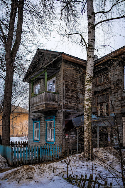 Старый деревянный двухэтажный дом с балконом