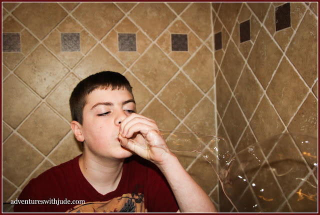 middle school child blowing bubbles with his hand instead of a bubble wand