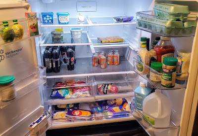 refrigerator with fresh vegetables, salad, eggs, butter, condiments, and an excess of cheese