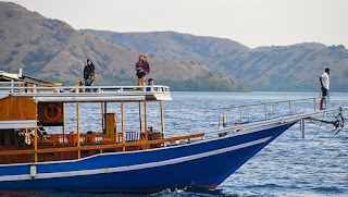 Wisatawan berpose di atas perahu pinisi di sekitar Pulau Kalong, Nusa Tenggara Timur, 2 Juli 2021. Kapal pinisi menjadi pilihan terbaik untuk menuju objek wisata Pulau Komodo, Pantai Pink, Manta Point, Pulau Padar, dan Pulau Kelor. Wisatawan yang ingin melakukan perjalanan singkat ke beberapa destinasi wisata disana dapat juga bisa menggunakan kapal cep. ANTARA FOTO/Rivan Awal Lingga