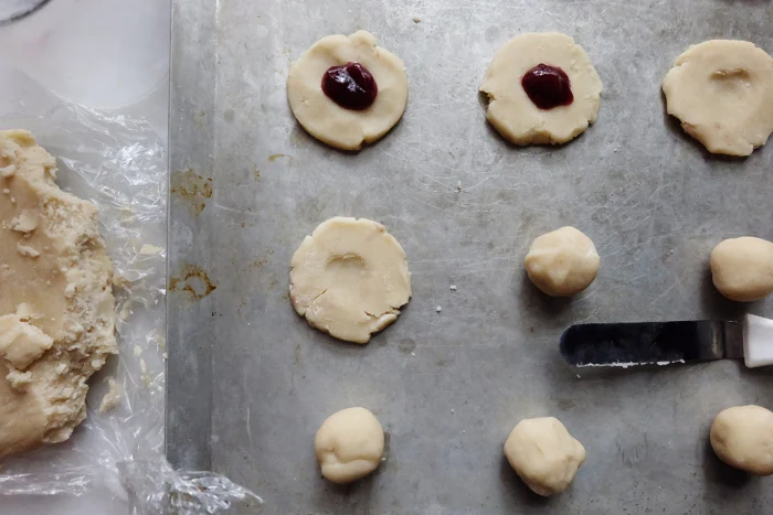 flattening cookie dough on baking sheet