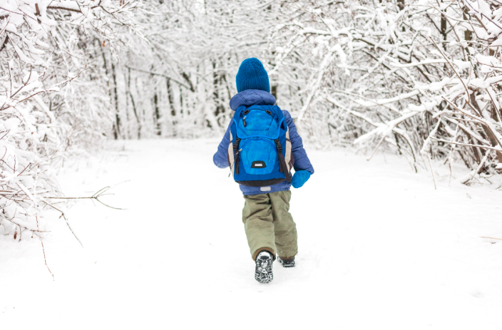 boy walking through snow