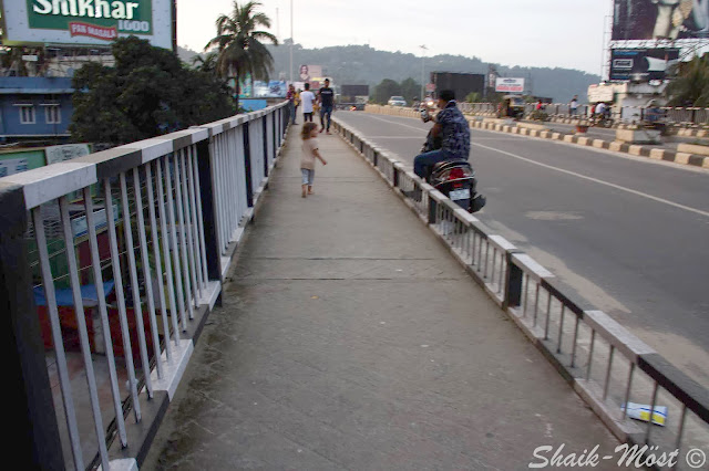 Nora running along a flyover bridge and interacting with locals in Guwahati