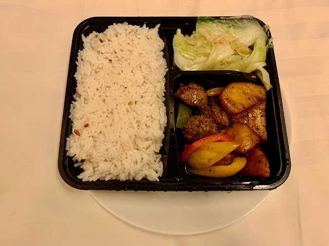 Divided takeaway tray with rice, cabbage and fake meat with potatoes