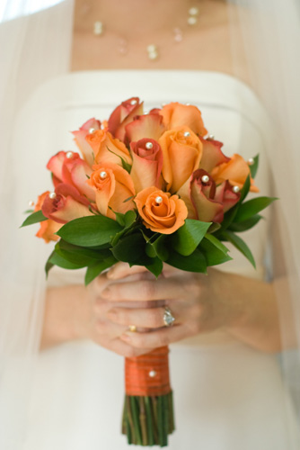 A bridal bouquet made up of beautiful orange roses can signify the burning 