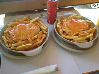 foto do sanduíche francesinha onde se vê mais o ovo frito e as batatas fritas