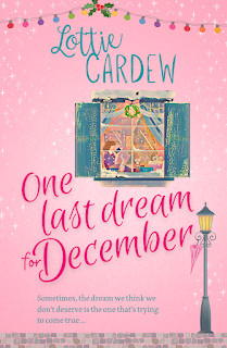 Pink cover of One Last Dream for December by Lottie Cardew features a window with a redheaded woman sitting reading a book. There is a vintage lampost under the window with a pink umbrella dangling from it.