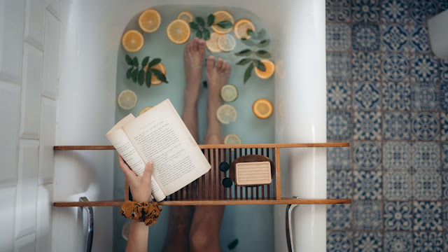 woman relaxing in a bathtub with a book