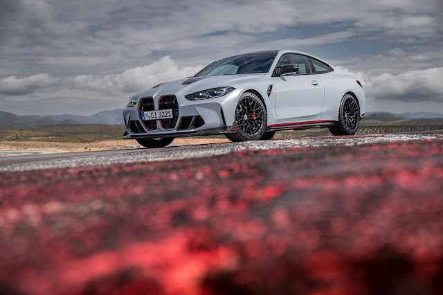 2023 BMW M4 CSL in Frozen Brooklyn Grey metallic; front and left side view, low shot with red curb of race track for foreground.