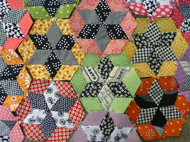 scrap quilt diamond English paper pieced blocks appliquéd onto a black background