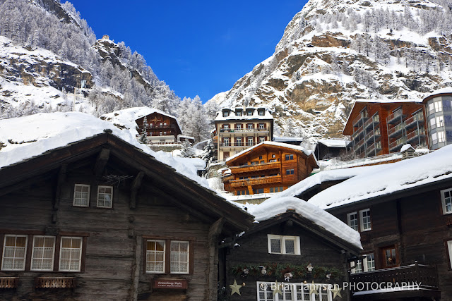 Quaint Alpine village houses climb the slopes of the Swiss Alps.