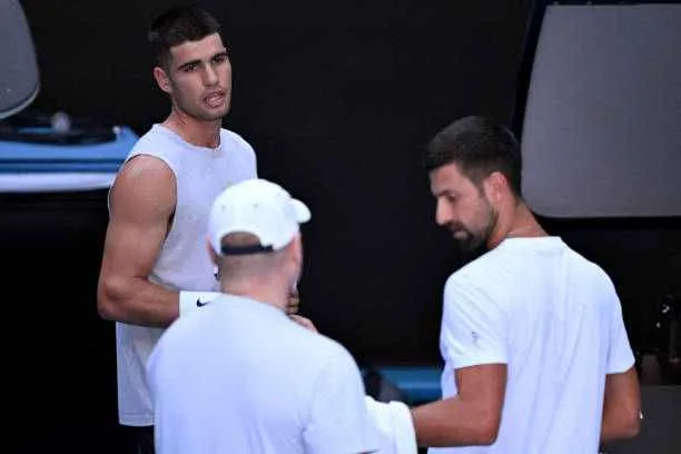 Spain's Carlos Alcaraz (L) talks with Novak Djokovic of Serbia (R) during a training session ahead of the Australian Open in Melbourne on January 7, 2025. Photo by William West/AFP/Getty Images
