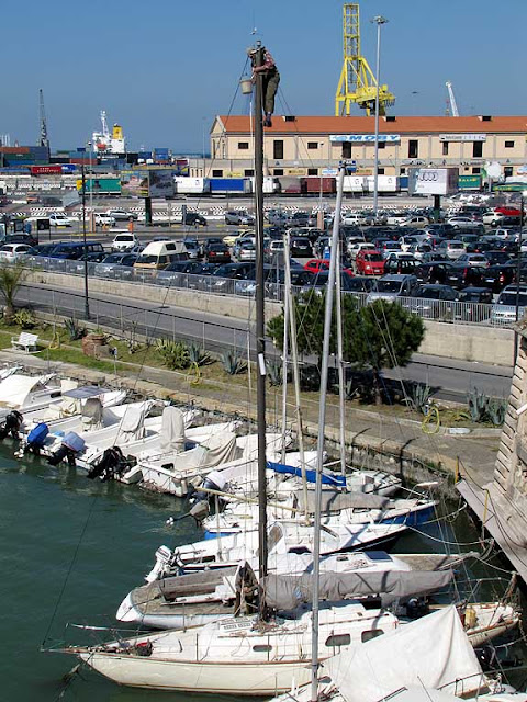 Working on top of the mast of a sailboat, Livorno