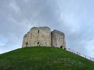 Clifford's Tower, which is a round stone keep sitting on top of a grassy hill.