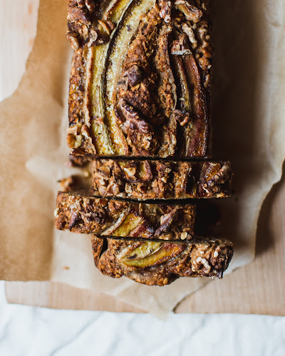 A loaf of banana bread with three sliced pieces