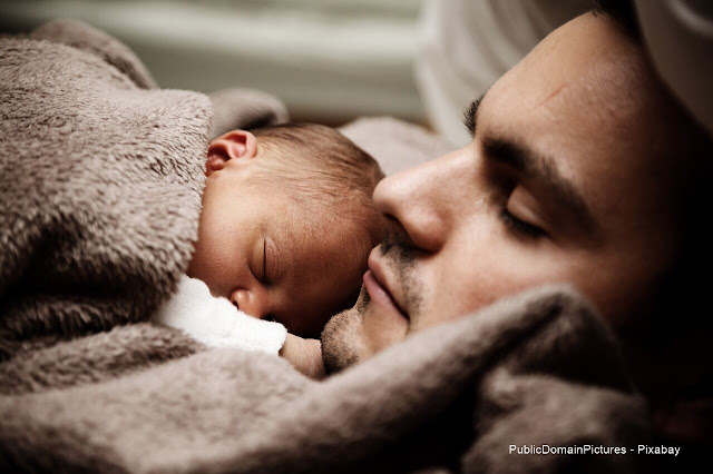 Homem e~bebé dormindo.