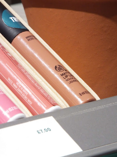 The Body Shop Matte Liquid Lip on the makeup counter, in a nude shade.